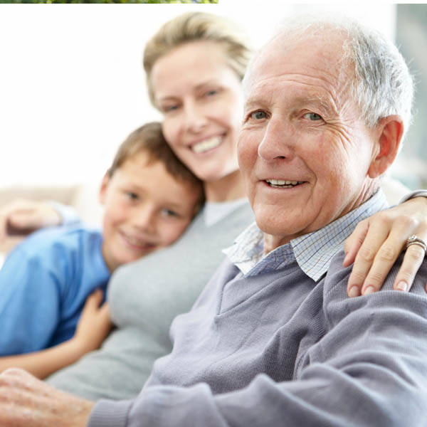 A smiling family with the grandfather in focus.