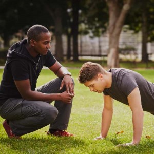 Workout partners, one doing a pushup while the other counts.