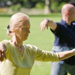 Older woman and man practicing tai chi.