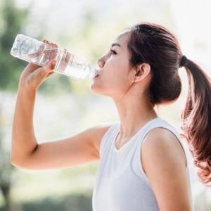 Woman drinking from a water bottle.